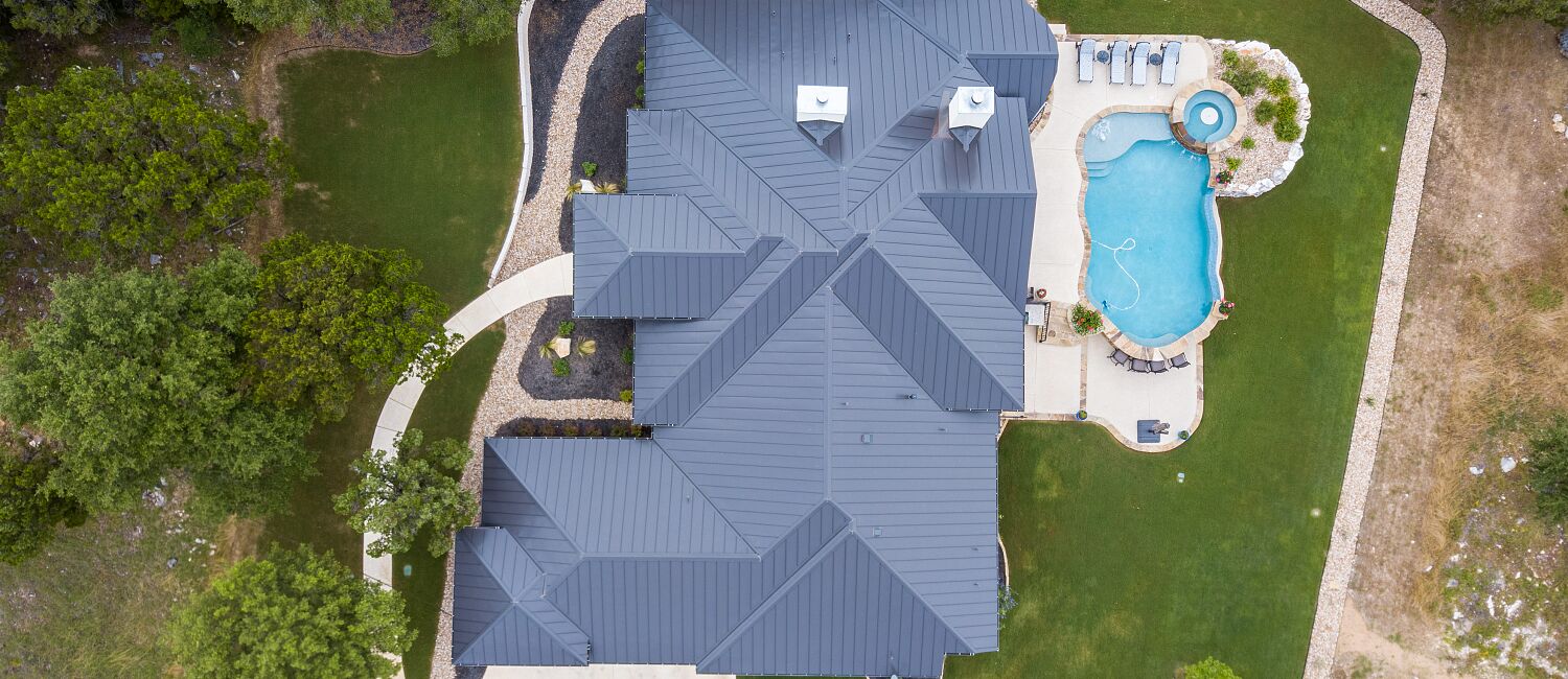 Aerial view of luxury modern home with a large pool and outdoor living area, San Antonio TX